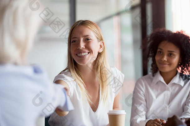 微笑女员工握手的同事公司会议
