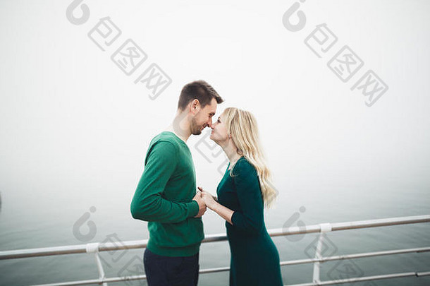 可爱的夫妇接吻拥抱海码头