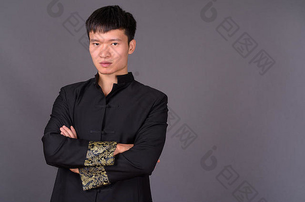 工作室拍摄年轻的中国人男人。灰色的背景