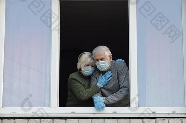 祖父祖母窗口保护面具孤立的首页检<strong>疫病</strong>毒爆发老男人。女人科维德流感大流行冠状病毒预防社会距离