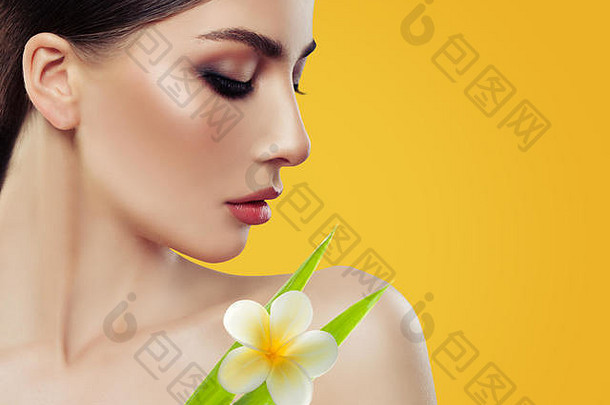年轻的女人化妆绿色叶子热带花黄色的背景