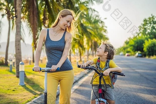 活跃的学校孩子男孩妈妈骑自行车背包阳光明媚的一天快乐孩子骑自行车学校安全孩子们在户外学校