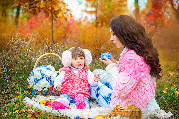 年轻的妈妈。女儿野餐公园秋天