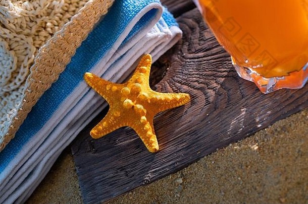 新鲜的橙色水果汁站玻璃稻草海滩毛巾谎言桑迪海滩