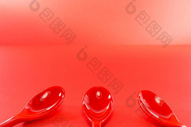 红色的塑料勺子红色的背景