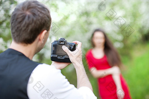 摄影师采取照片美丽的女人红色的衣服自然