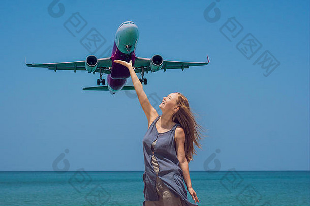 年轻的女人海滩着陆飞机旅行概念