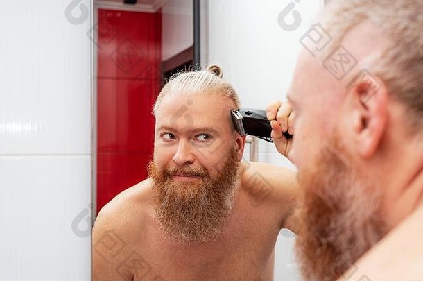 英俊的有胡子的男人。切割头发头发限幅器浴室前面镜子首页头发护理检疫特写镜头