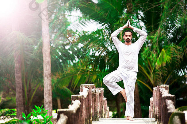 男人。穿白色瑜伽热带丛林桥
