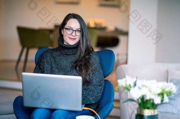 拍摄微笑年轻的女人移动PC坐着椅子工作首页
