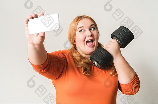 胖乎乎的女人体育运动首页站孤立的白色采取自拍照片哑铃兴奋