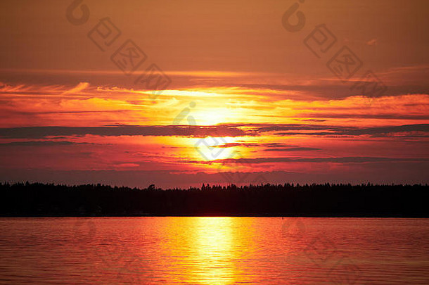 红色的日落天空太阳色彩斑斓的云和平海瓦萨芬兰明亮的磁盘太阳部分隐藏的云