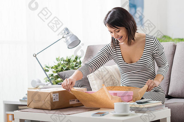 快乐兴奋女人首页收到了邮政包裹unboxing礼物交付在线购物概念
