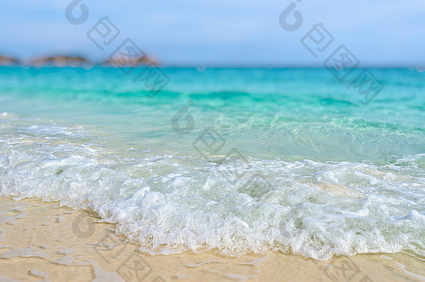 Tilt-shift软模糊效果美丽的自然背景蓝色的海沙子白色波海滩夏天