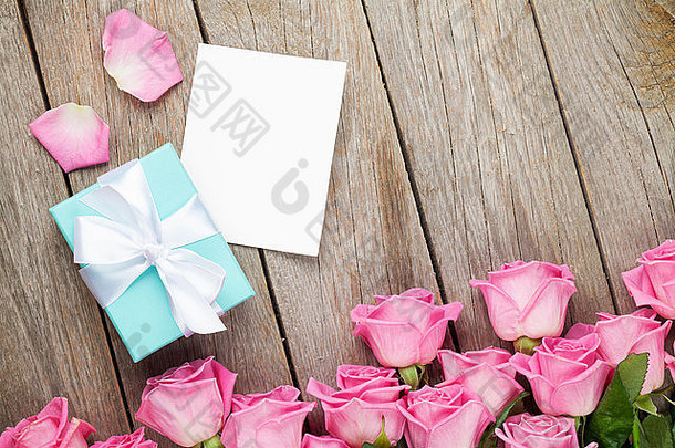 粉红色的玫瑰情人节一天问候卡照片框架礼物盒子木表格前视图复制空间