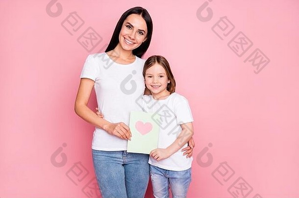 照片漂亮的年轻的妈妈女儿持有3月惊喜明信片心脏感情拥抱穿休闲t恤牛仔裤孤立的柔和的粉红色的