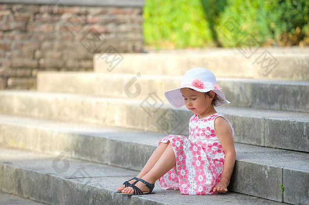 可爱的女孩穿白色他坐着楼梯温暖的阳光明媚的夏天一天