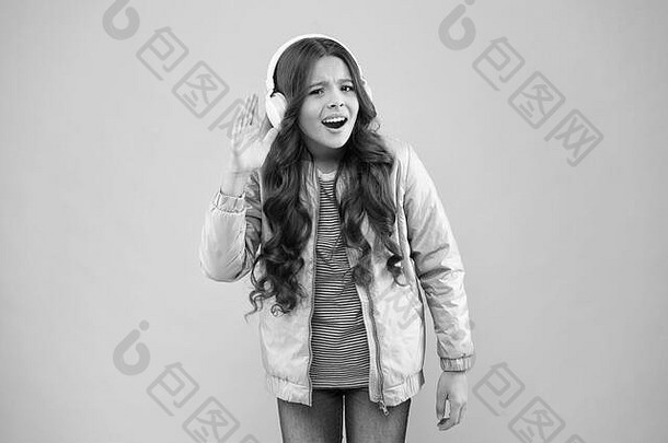 听到音乐快乐快乐孩子听音乐粉红色的背景女孩穿耳机玩音乐技术孩子们有趣的娱乐现代生活方式