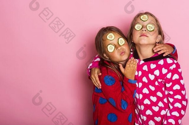 孩子们构成粉红色的背景发送吻复制空间女孩色彩斑斓的波尔卡虚线睡衣拥抱童年友谊幸福概念孩子们黄瓜脸宽松的头发