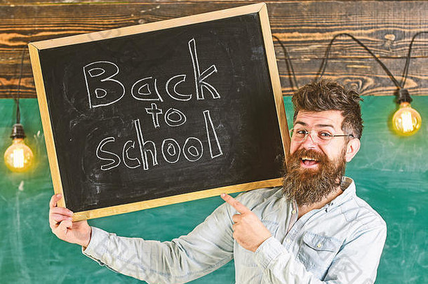 老师眼镜持有黑板上标题回来学校男人。胡子胡子快乐脸欢迎的同事们黑板背景招聘老师概念