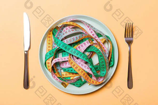 前视图色彩斑斓的测量磁带板形式意大利面刀叉橙色背景重量损失饮食概念