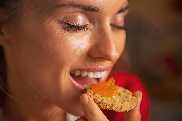 肖像年轻的女人吃饼干橙色小时