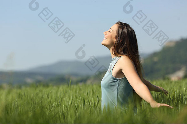 一边视图肖像快乐女人呼吸新鲜的空气触碰小麦绿色场