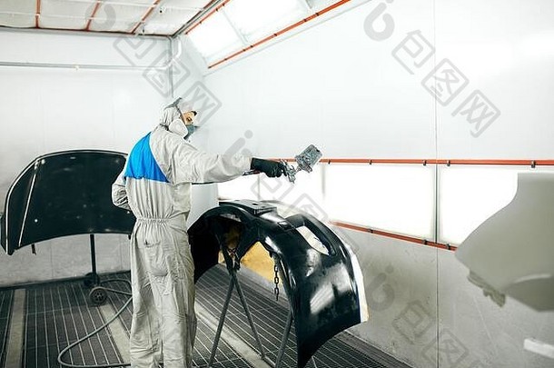 年轻的工人绘画车部分特殊的车库穿服装保护齿轮