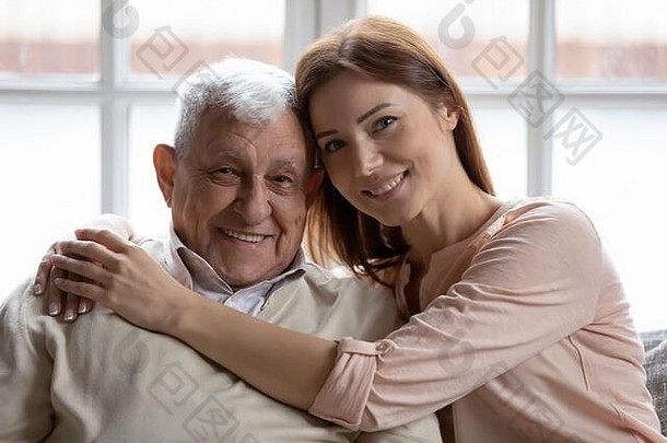 <strong>有</strong>爱心的成人（外）孙女拥抱上了年纪的祖父坐着沙发