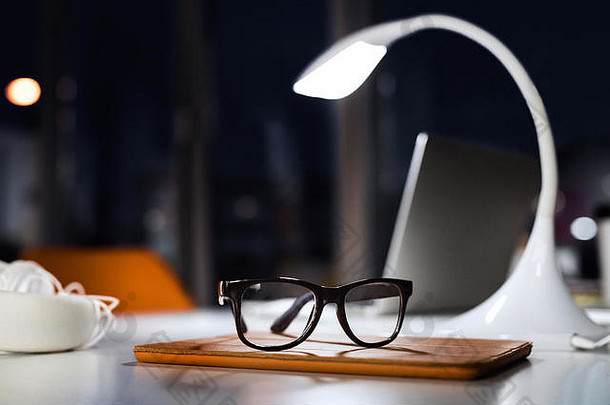 办公室桌子上晚上眼镜灯平板电脑