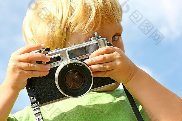 年轻的男孩指出古董相机查看器玩