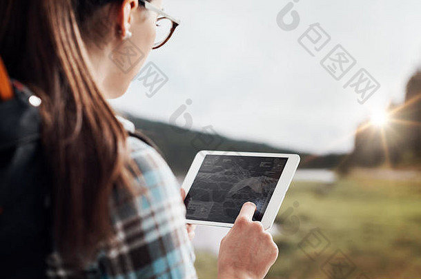 年轻的女徒步旅行者走自然连接数字平板电脑技术沟通概念