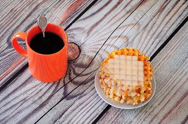 堆栈新鲜的华夫饼糖浆橙色杯子黑色的咖啡木表格特写镜头