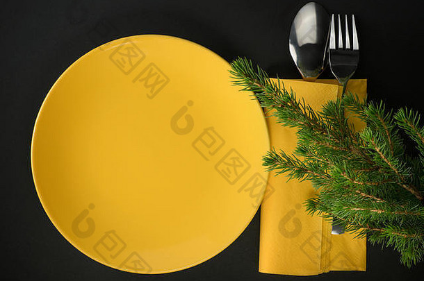 黄色的板餐具冷杉分支机构黑色的背景前视图圣诞节晚餐主题作文