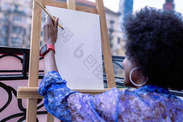 非裔美国人艺术家穿红色的聪明的看工作