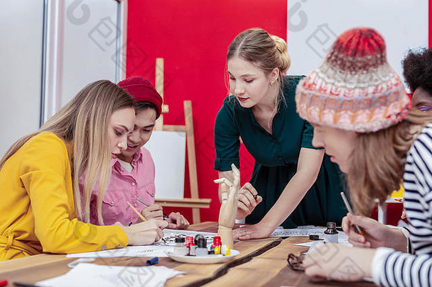 金发团队领袖帮助艺术学生绘画