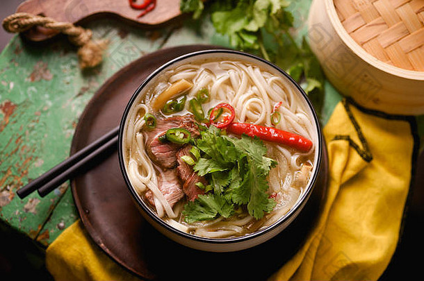 越南传统的汤巨像牛肉新鲜的香菜乡村木表格