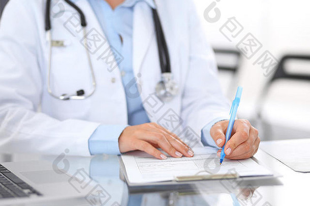 未知的医生女人工作手特写镜头女医生填充医疗形式坐着玻璃桌子上医院办公室医学医疗保健概念