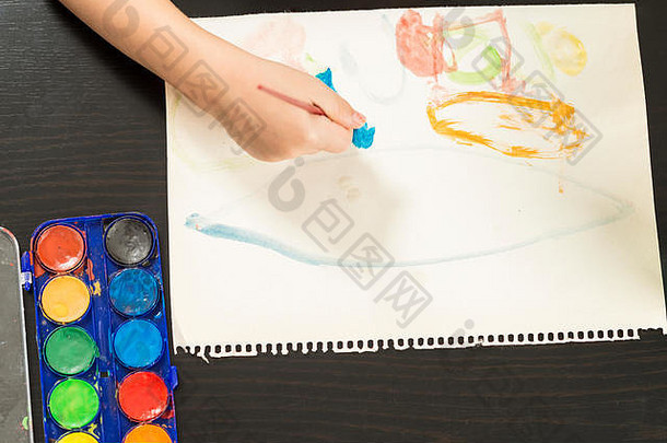 细节孩子的手采取刷绘画水彩画纸概念童年教育回来学校