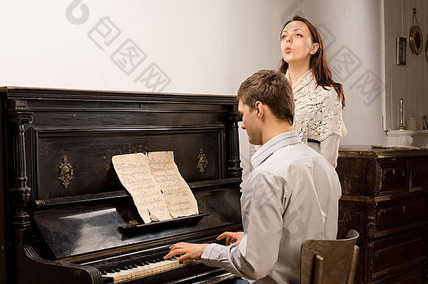 年轻的夫妇练习音乐的二重唱