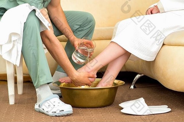 按摩治疗师洗女人的脚按摩过程水疗中心美沙龙