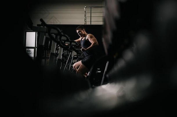 肌肉发达的运动男人。锻炼模拟器体育运动锻炼现代健身房