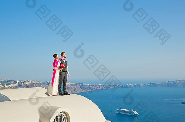 年轻的快乐的夫妇度蜜月希腊岛圣托里尼岛
