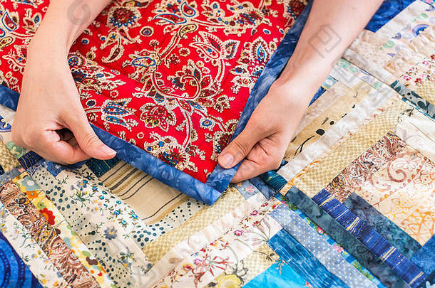 高加索人女手触碰颜色拼接而成被子蓝色的几何模式部分色彩斑斓的不连贯的毯子手工制作的