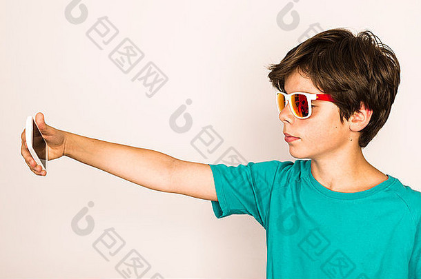 快乐年轻的男孩太阳镜自拍聪明的电话首页孤立的白色背景