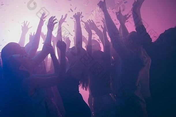 关闭照片节日兴奋人跳舞泡吧紫色的灯五彩纸屑雾夜总会手提高了闪亮的正式的服装