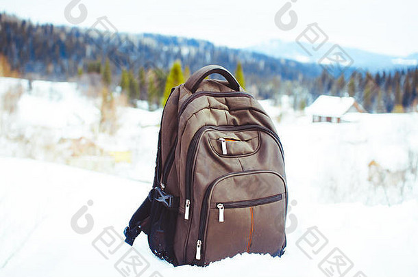 背包背景白雪覆盖的山蓝色的天空背包雪活跃的生活方式徒步旅行冬天