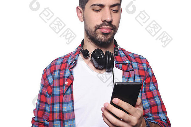 肖像年轻的拉丁男人。打字智能手机黑色的耳机孤立的白色背景
