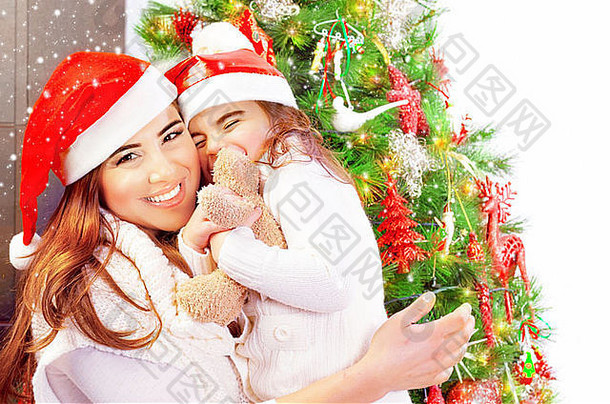 肖像有吸引力的女人女儿庆祝一年首页穿红色的<strong>圣诞</strong>老人帽子女孩收到礼物软玩具