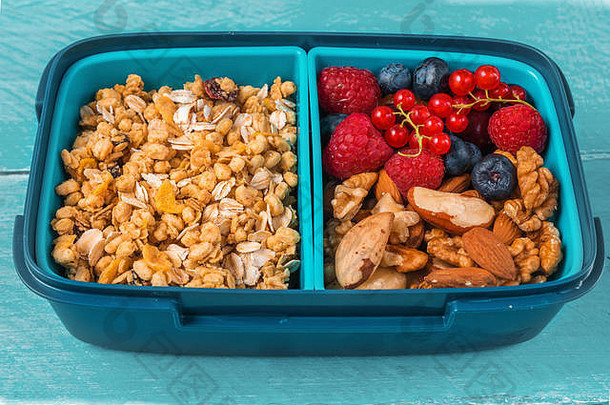 健康的学校午餐盒子格兰诺拉麦片坚果浆果使健康的早餐蓝色的木背景关闭